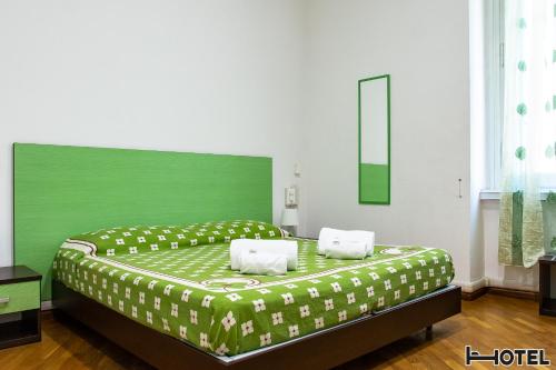 a green bed with two pillows on it in a room at Hotel Youri Il Magnifico in Genova