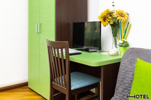 a desk with a computer on a green desk at Hotel Youri Il Magnifico in Genova