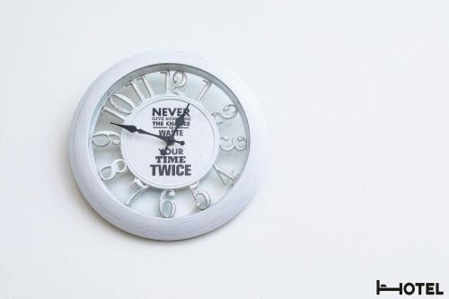 a clock is hanging on a white wall at Hotel Youri Il Magnifico in Genova