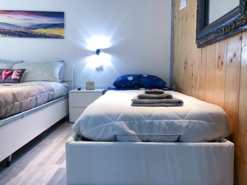 a bedroom with two beds and a bed with towels on it at Central Greenlife in Tarvisio