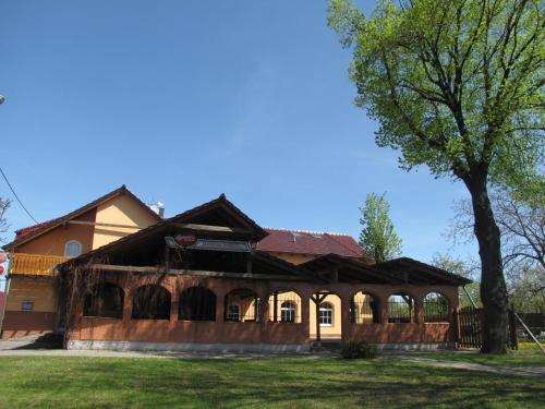 a house with a tree in front of it at Penzion Apartmány Adamčík in Huštěnovice
