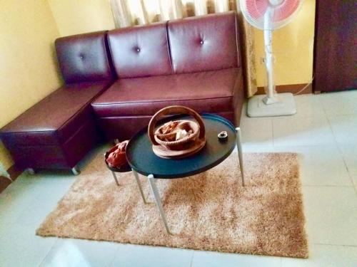 a living room with a couch and a table with a hat at Jireh’s Guests Home in Butuan