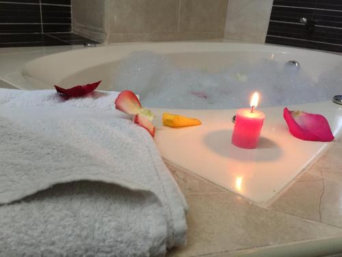 Suites El Parque في ليما: وجود شمعة جالسة على حوض الاستحمام مع منشفة