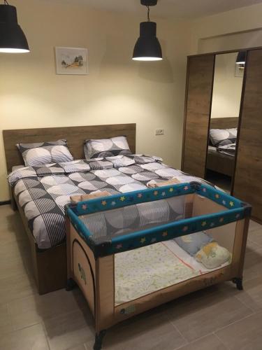 a bed with a crib in a room with a mirror at Sofia Family House - Free Parking in Sofia