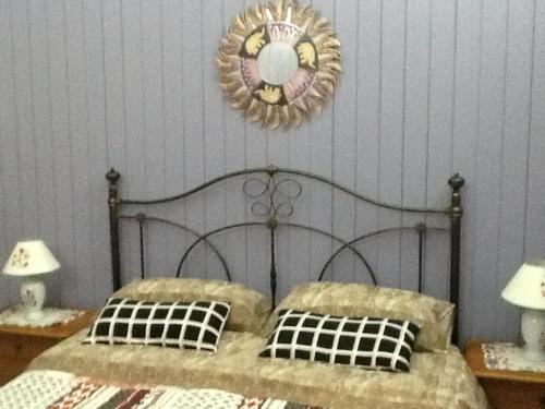 una camera da letto con un letto di metallo con due lampade e uno specchio di Gisira Apartments Al Borgo a Catania