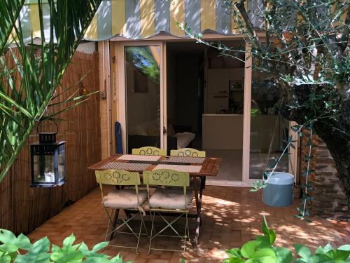 une table et deux chaises sur une terrasse dans l'établissement **** Beau T2 de 40 m2, jardin de 70m2, au calme, à 50 mètres de la plage, au Pradet