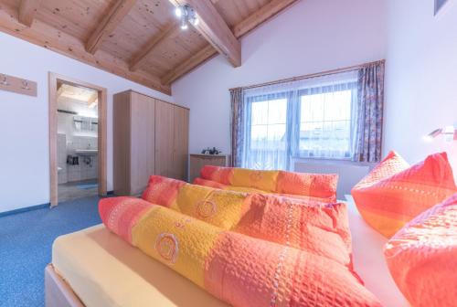 1 dormitorio con 1 cama con almohadas coloridas en Appartement Nicola, en Sölden