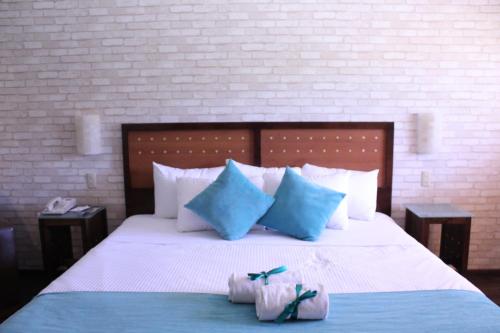 a bedroom with a bed with blue and white pillows at Hotel Colonial Hermosillo in Hermosillo