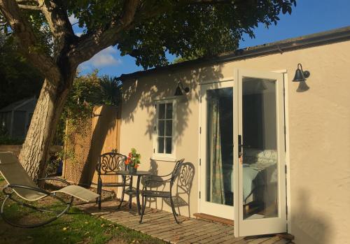 a patio with a table and chairs next to a house at Corner House Luxury BnB in Little Dunmow