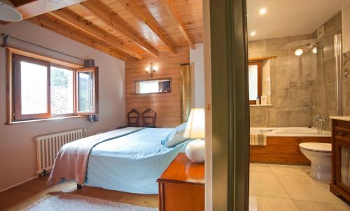 um quarto com uma cama e uma casa de banho com uma banheira em Casa Melendreros em Melendreros