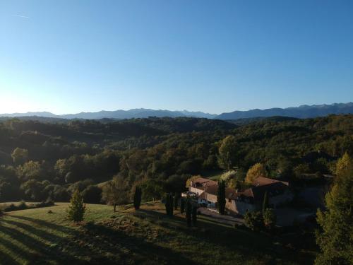 a house on a hill with a view of a valley at Chambres d'Hôtes Secret Pyrenées in Lasseube