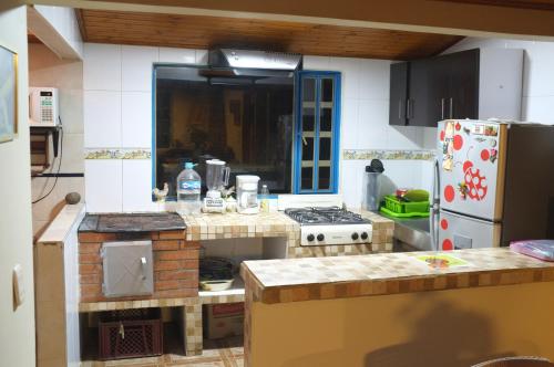 a kitchen with a stove and a refrigerator at Cabañas Yukatan Lago de Tota in Tota