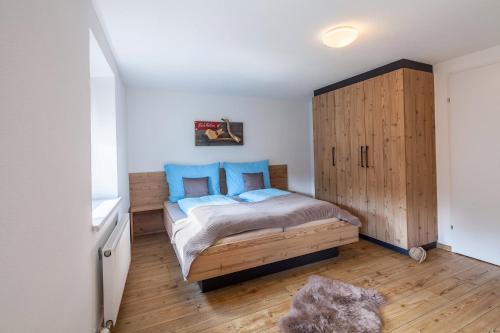 um quarto com uma cama e um armário de madeira em Ferienwohnung bei Cooldog em Imst