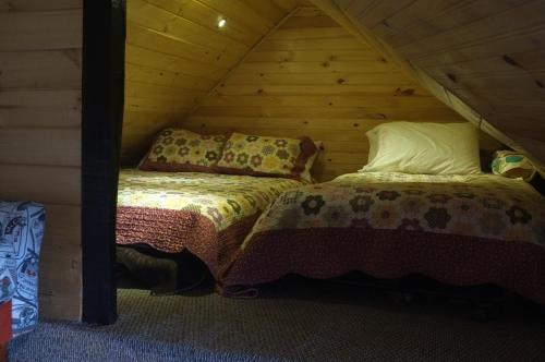 a bedroom with two beds in a log cabin at Cabañas Yukatan Lago de Tota in Tota