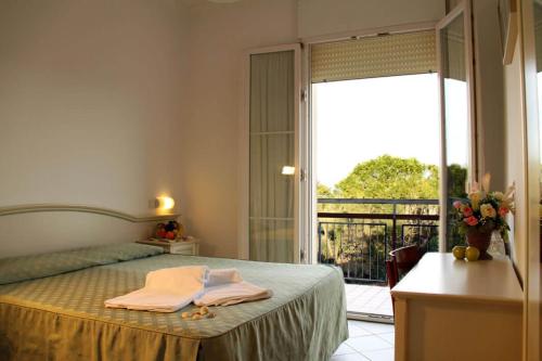 una camera con letto e vista su un balcone di Ariston Vacanze a Marina di Ravenna