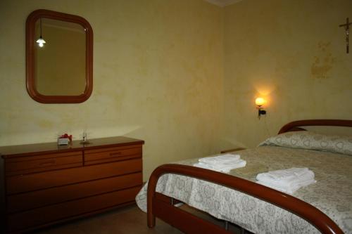 a bedroom with a bed and a dresser and a mirror at Mansarda Accogliente in San Giovanni Rotondo