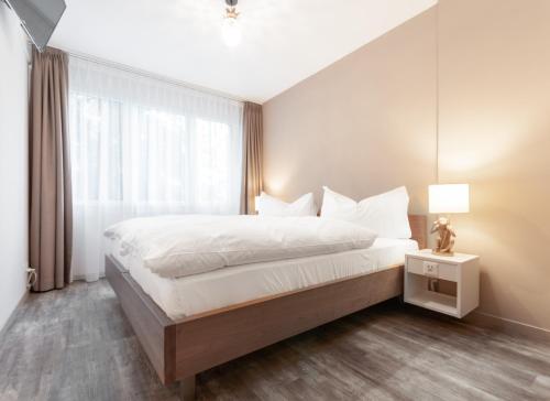 a bedroom with a large bed and a window at Hotel Birsighof Basel City Center in Basel