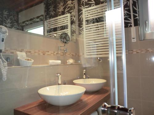 a bathroom with two white sinks on a wooden counter at Hotel Altenberg in Baden-Baden