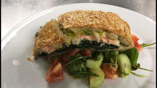 a sandwich on a white plate with a salad at Hotel Hromovka in Špindlerův Mlýn