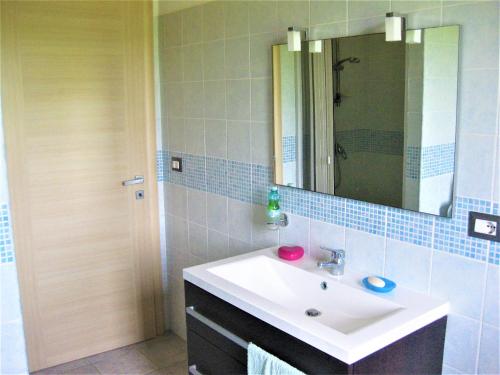 a bathroom with a sink and a mirror at Su Cuile relax house with barbecue in Martis