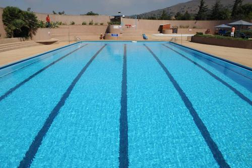 a large swimming pool with blue water at Ein Zivan Village Resort in Ein Zivan