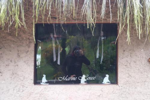 a person taking a picture in a window with a camera at Cabañas Yukatan Lago de Tota in Tota
