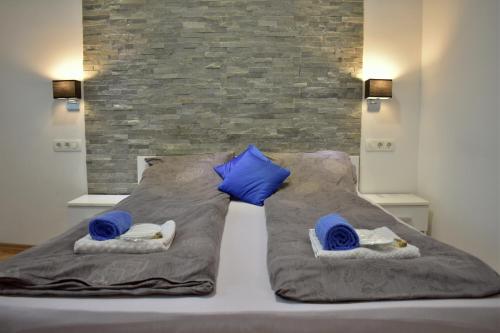 a bed with blue pillows and towels on it at Apartment Nejra in Sarajevo