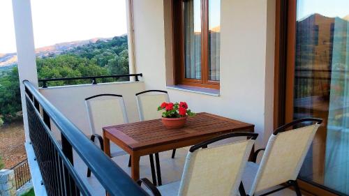 a wooden table and chairs on a balcony at Petrochori ApartHotel in Petrochori