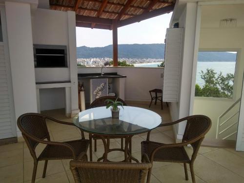 une salle à manger avec une table et des chaises et une vue dans l'établissement Residencial Jardim dos Beija- Flores, à Bombinhas