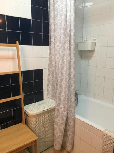 a bathroom with a shower curtain next to a bath tub at Casa da Bia in Quarteira