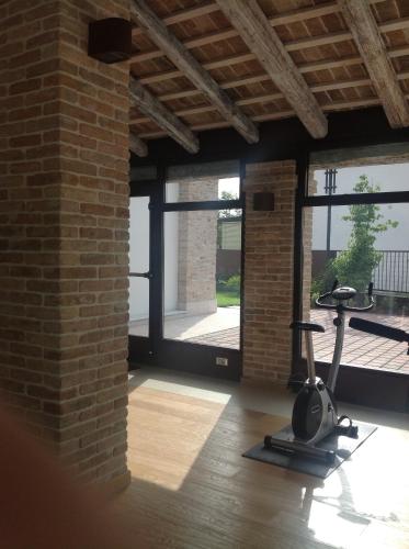 a room with a brick wall and a gym with a treadmill at Do Ciacole In Relais in Mira