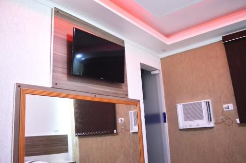 a room with a tv and a door with a mirror at Hotel Gold in Sao Paulo