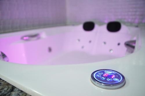 a white bath tub with a remote control in it at Hotel Gold in Sao Paulo