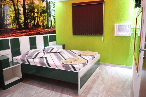 a bedroom with a bed with a green wall at Hotel Gold in Sao Paulo