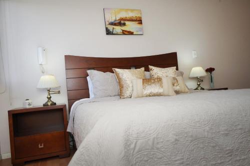 Vega Apartment for Rent في كيتو: غرفة نوم بسرير ابيض كبير ومصباحين