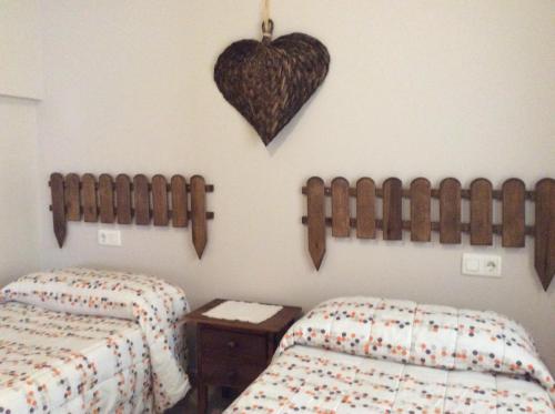 a bedroom with two beds and a heart on the wall at Apartamento Rural Castildetierra in Arguedas