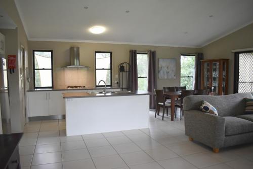 cocina y sala de estar con sofá y mesa en Melawondi Spring Retreat, en Imbil
