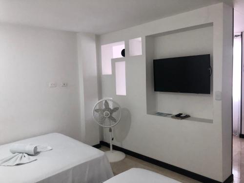 a white room with a fan and a flat screen tv at Apartamentos Martinez in San Andrés
