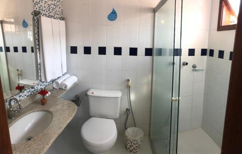a bathroom with a toilet and a sink and a shower at Porto Geraes Praia Hotel in Porto Seguro