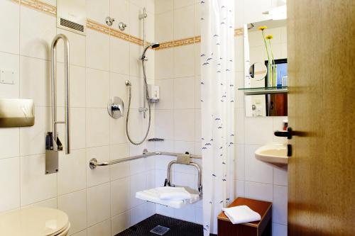 a bathroom with a shower and a toilet and a sink at Ringhotel Gasthof Hasen in Herrenberg