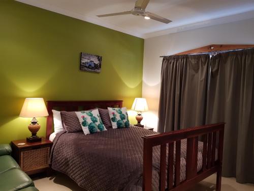 a bedroom with a bed and a green wall at Sonja's Bed and Breakfast in Lightning Ridge