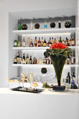 a table with glasses and a vase with a flower at Culture Hotel Centro Storico in Naples