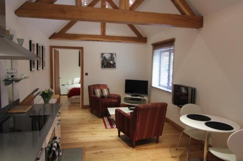 a kitchen and living room with a table and chairs at Ashbrook Lets Apartments in Blewbury