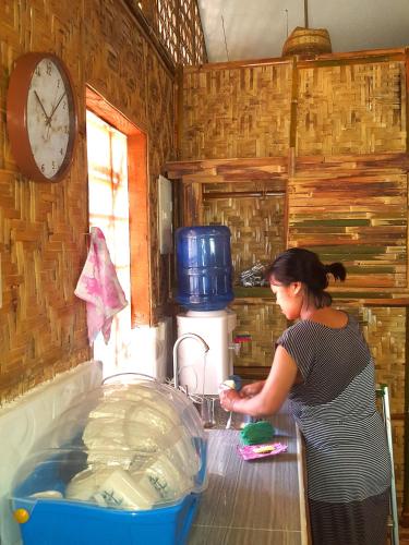 a woman standing at a counter in a kitchen at MJ Room Rental in Panglao