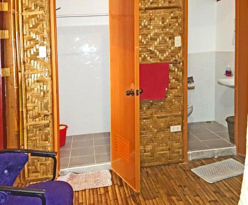 a bathroom with a door and a sink and a toilet at MJ Room Rental in Panglao