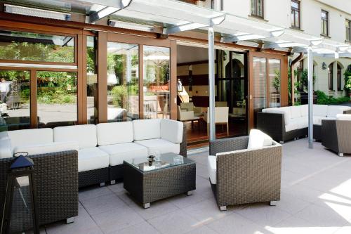 a patio with white couches and tables and windows at Ringhotel Gasthof Hasen in Herrenberg