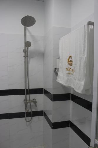 een badkamer met een handdoek aan een douchecabine bij Phuc Hau Hotel in Con Dao