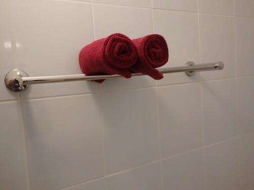 two red towels on a towel rack in a bathroom at Leelawadee Khao-lak in Khao Lak