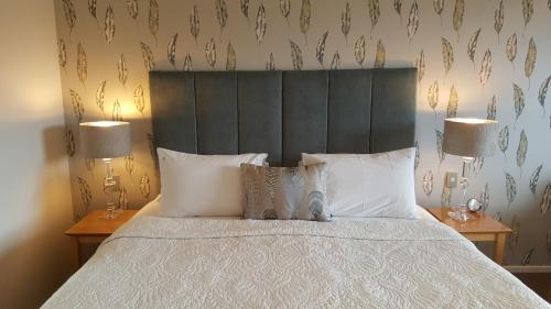 a bedroom with a large bed with white sheets and pillows at Bluestone On George in Dunedin