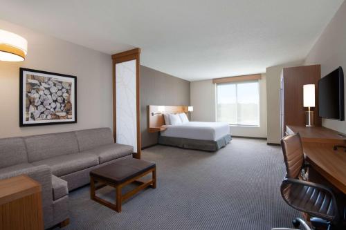 a hotel room with a couch and a bed at Hyatt Place Westminster Denver in Westminster
